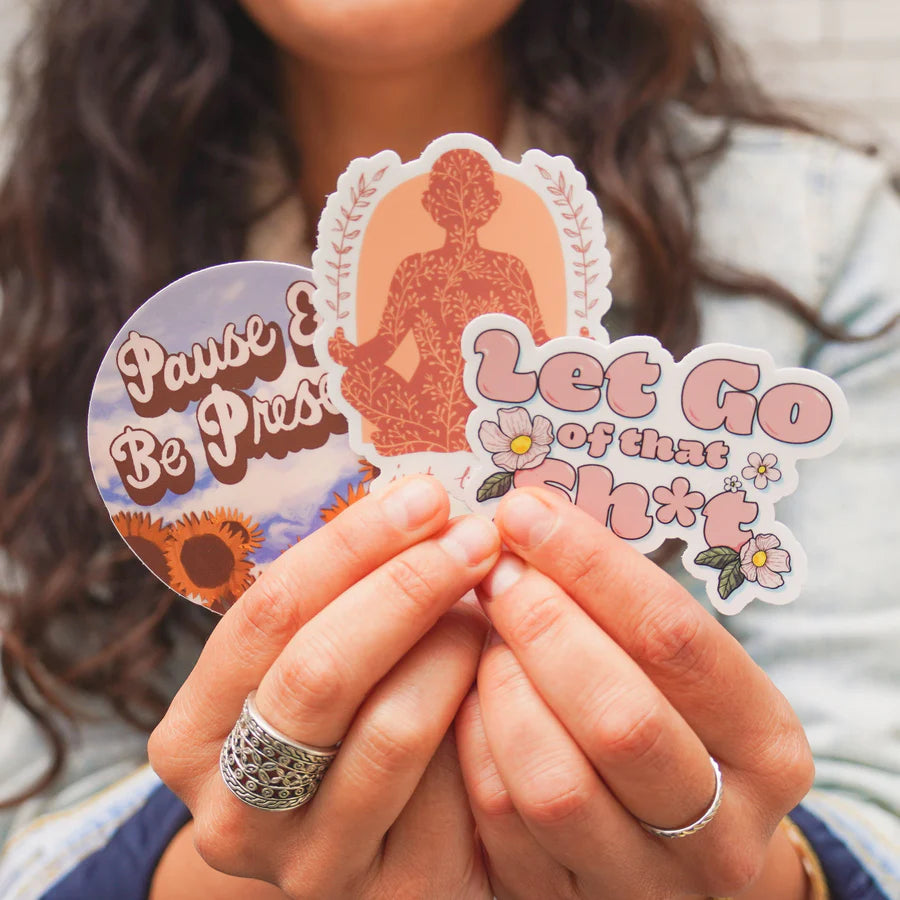 hands holding three stickers