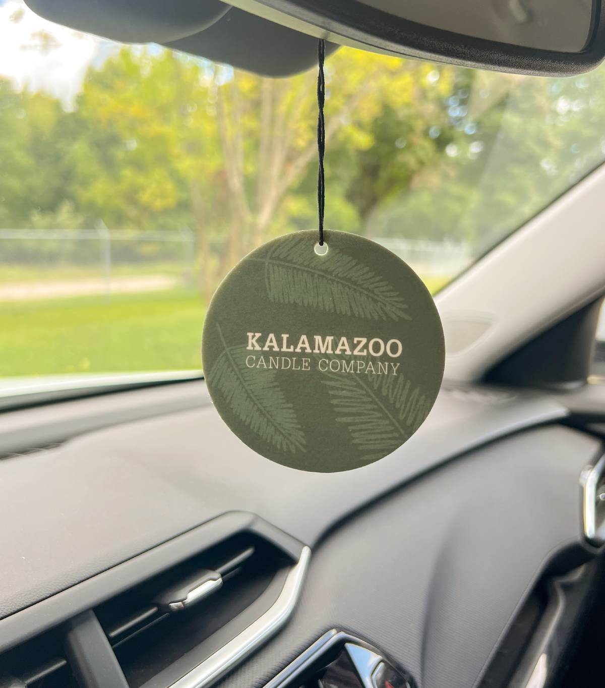 The Back of a Balsam & Cedar Car Freshener hanging in a car.