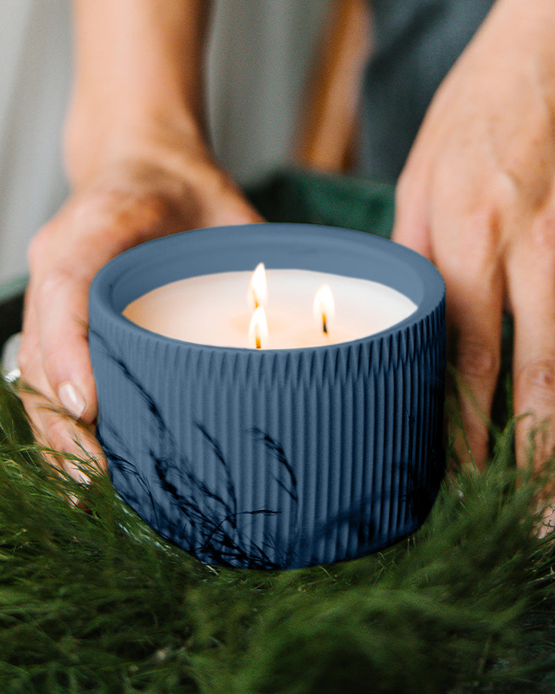 A Dark Blue colored 3-Wick Ceramic Candle scented like River Moss &amp; Teakwood.