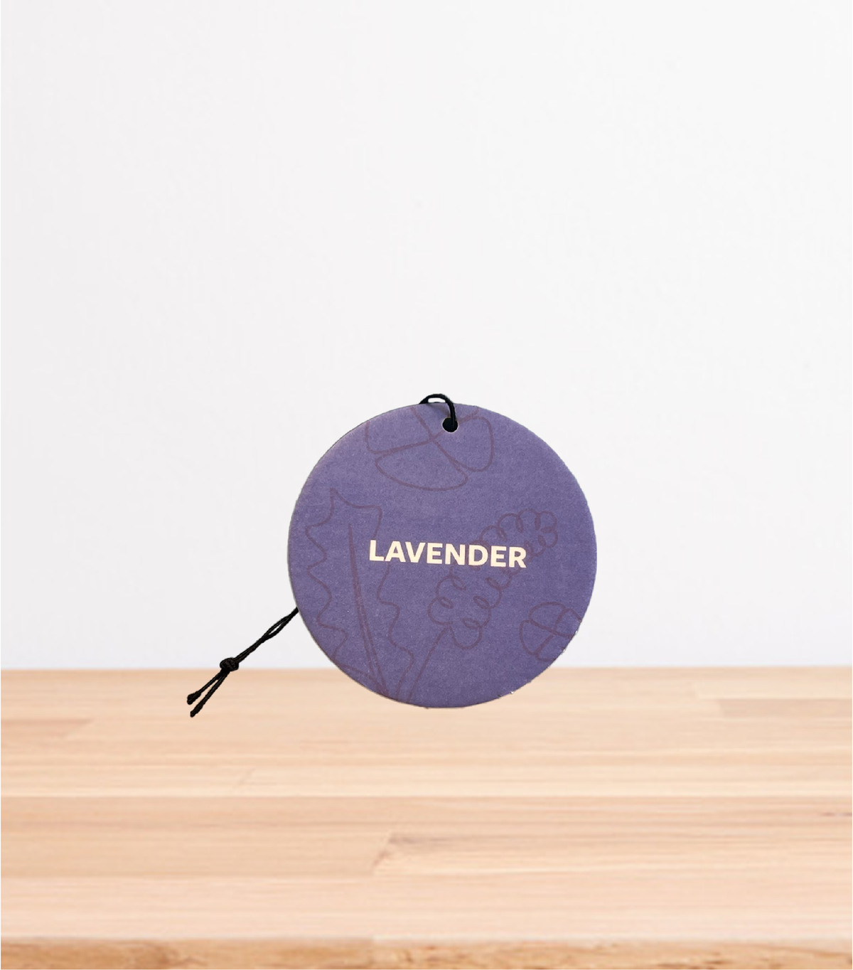 A Lavender car freshener on a wooden table
