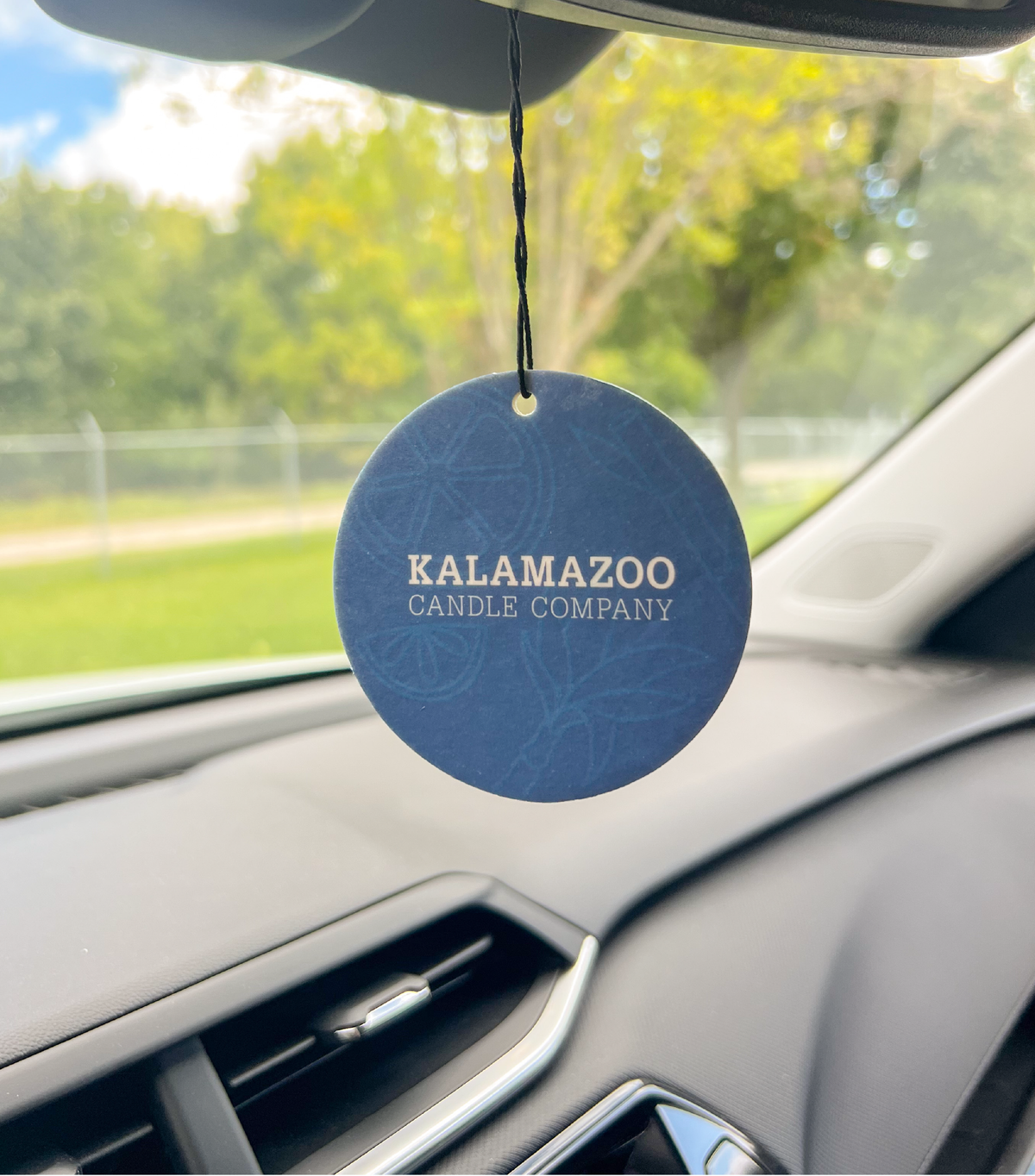 The Back of an Obsidian Car Freshener hanging in a car.