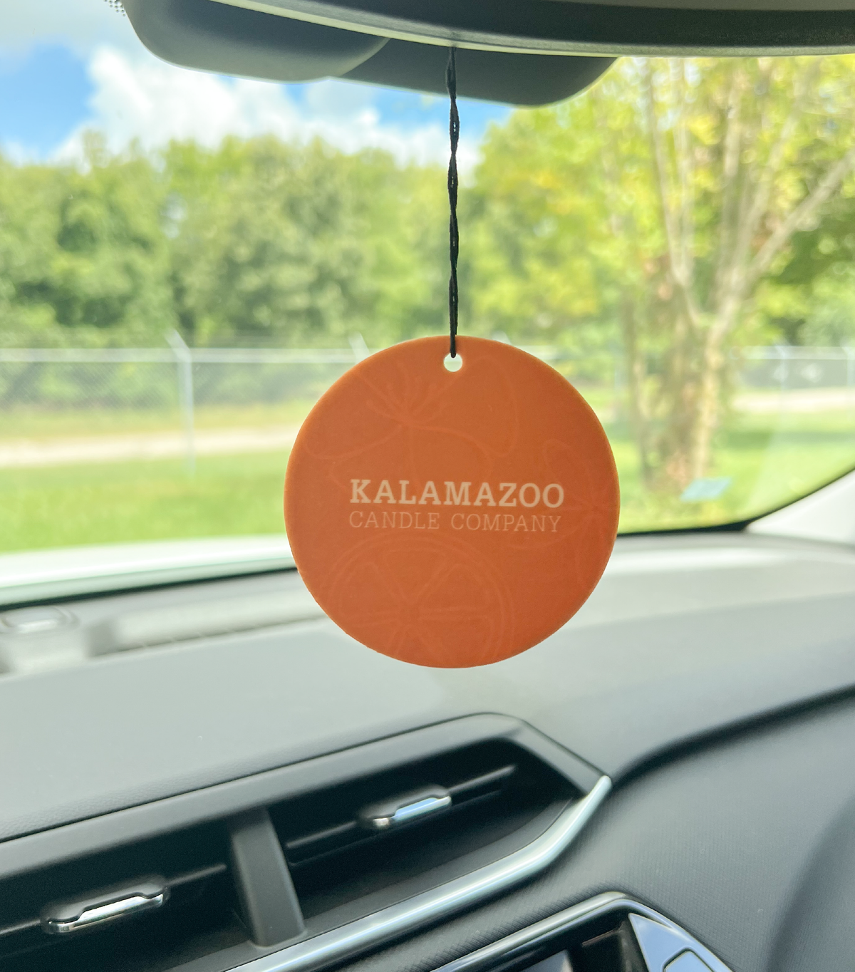 The Back of a Smitten Car Freshener hanging in a car.